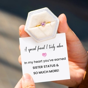 Close-up of heart-shaped pink gemstone ring in a velvet box with friendship card
