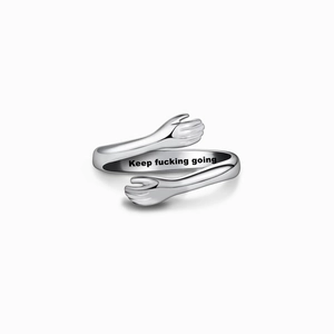 Détail d'une bague de câlin en argent avec la gravure intérieure 'Keep fucking going'