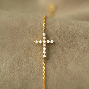 Macro shot of s925 silver cross bracelet featuring brilliant zircon inlays on a gold chain