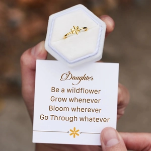 Detail of golden flower ring with diamond center in a hexagonal velvet jewelry box