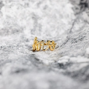 Elegant gold S925 sterling silver ring with script Love design on a grey stone background