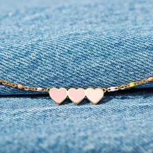 S925 silver gold-plated bracelet with gradient pink enamel hearts on denim background