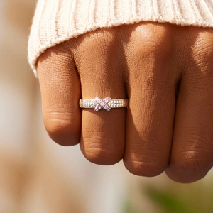 Bague croisée élégante en argent 925 avec zircon rose sur le doigt d'une femme