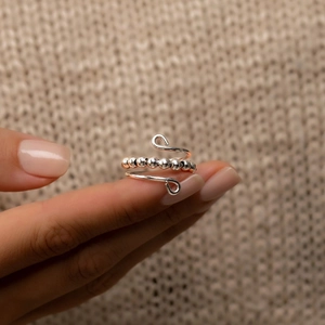 S925 sterling silver spinning beads anxiety ring on finger with soft knit background