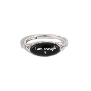 Macro shot of silver adjustable ring featuring I am enough quote with a red heart