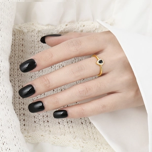 Elegant gold heart ring with pear-cut black gemstone and white zircon stones on model's hand