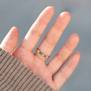 Gold s925 silver ring featuring black Trust God engraving on hand with knit sweater