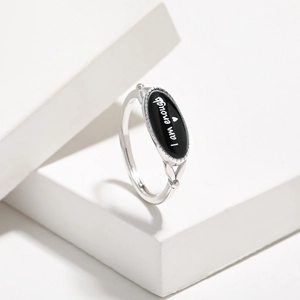 Macro detail of S925 sterling silver ring with 'I am enough' engraved black agate oval face