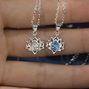 Handheld view of S925 sterling silver lotus necklace with white and blue teardrop stones