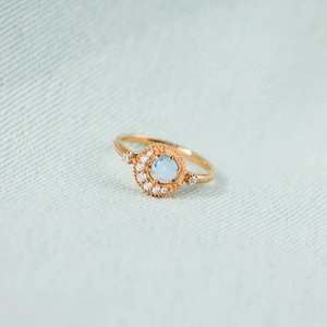 Bague planète en argent S925 avec opale et halo de diamants sur tissu bleu clair