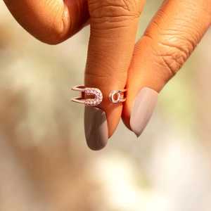 Detail of rose gold safety pin ring featuring shimmering pink micro-pave crystals