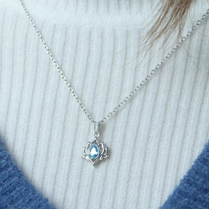 S925 sterling silver lotus necklace with blue teardrop stone worn on model