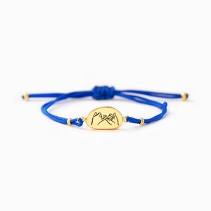 Bracelet en corde tressée bleue avec breloque ovale dorée et motif de promesse