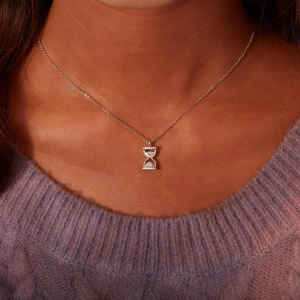 Élégant collier sablier en argent sterling S925 avec zircons sur un pull en maille violet