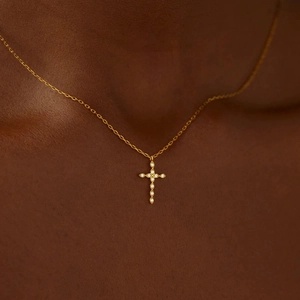 Macro shot of s925 silver gold-plated infinity cross necklace with cubic zirconia