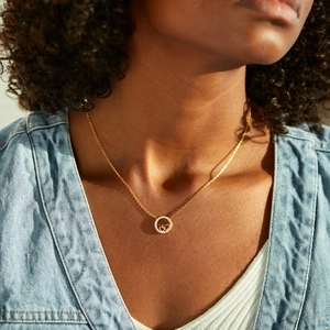 Elegant gold double heart necklace with crystal ring on model in natural light