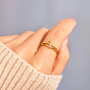 Bague double couche en argent s925 dorée avec pierres de cœur roses sur la main d'un mannequin