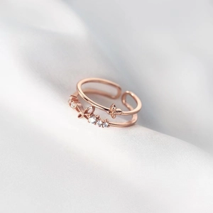 Detail of rose gold double-layer butterfly ring with zircon on white silk background