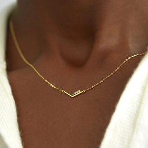 Vue macro du collier en argent S925 doré en forme de V avec trois pierres de naissance