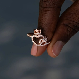 Close-up of rose gold heart crown ring with micro-pave crystals on female hand