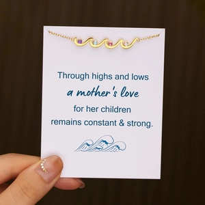 Detail of gold wave necklace with four colored birthstones on a mother sentiment gift card