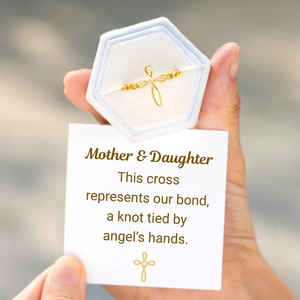 Gold infinity knot cross ring in a blue velvet box with a sentimental gift card for Mom