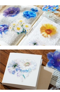 Primer plano de pegatinas de PET de flores translúcidas sobre libro y caja vintage