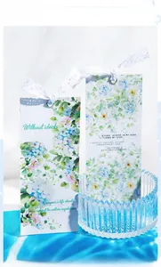 Detail of floral PET tape cards with blue hydrangea motifs and delicate white lace ties