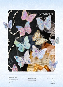 Close-up of butterfly stickers with holographic gemstone details on vintage paper