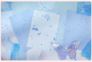 Blue artistic textured papers for DIY journaling with laser-cut butterfly decoration