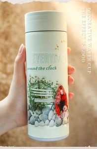 Detail of mint green tumbler with Everyday floral illustration and garden bench motif