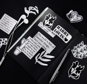 Macro-opname van minimalistische zwart-wit stickers op een notitieboekje met accessoires