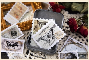 Detail of vintage stamp stickers with butterfly and map motifs in a metal storage box