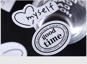 Detailweergave van zilveren hart- en ovale stickers met typografie op een zwarte ondergrond