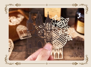 Macro detail of laser-cut paper art featuring Gothic cathedral and rose flower designs