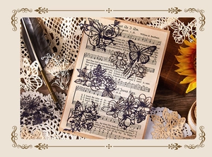 Close-up of laser-cut butterfly and flower scrapbooking paper on vintage music sheet