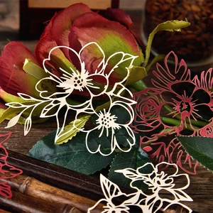 Exquisite laser-cut floral scrapbooking paper for DIY crafts on vintage wood surface