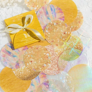 Aesthetic holographic decorative paper rounds in yellow gift box with ribbon