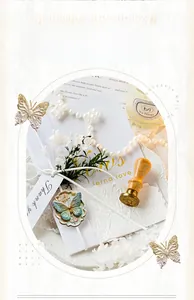 Dettaglio di sigillo in ceralacca vintage con farfalla, perle e nastri decorativi