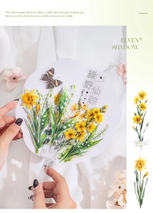 Detail of floral PET stickers on a transparent fan with green forest design elements
