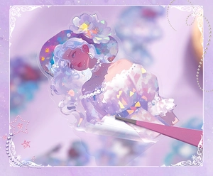 Macro shot of shell light girl sticker being peeled with pink tweezers for DIY journaling
