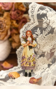 Detalle de pegatina vintage de chica con ramo morado sobre fondo de encaje fino