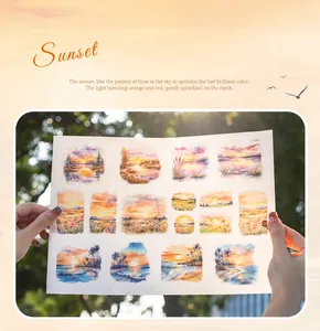 Detailed view of translucent sunset landscape washi stickers held in hands for journaling
