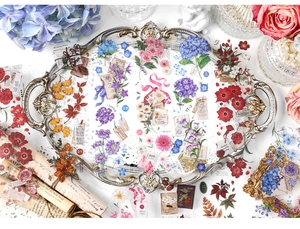 Macro detail of vintage floral PET stickers with daisy designs on a golden tray