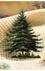Detailed view of pine tree PET sticker with die-cut edges on a warm knitted background