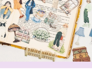 Detail von halbtransparenten PET-Stickern mit Blumen und Mädchenmotiven auf Buchseiten