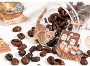 Makroaufnahme von Vintage-PET-Aufklebern mit Orangenkatze und Picknickkorb-Motiven