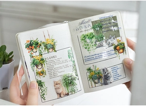 Detail of hanging plant and cat stickers on a dotted notebook for DIY journaling