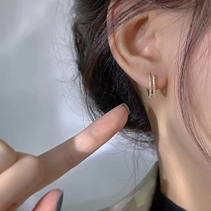 Élégantes boucles d'oreilles créoles S925 en argent doré à double rangée sur un modèle