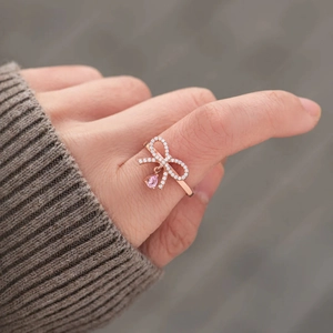 Rose gold S925 sterling silver bow ring with pink teardrop pendant on finger